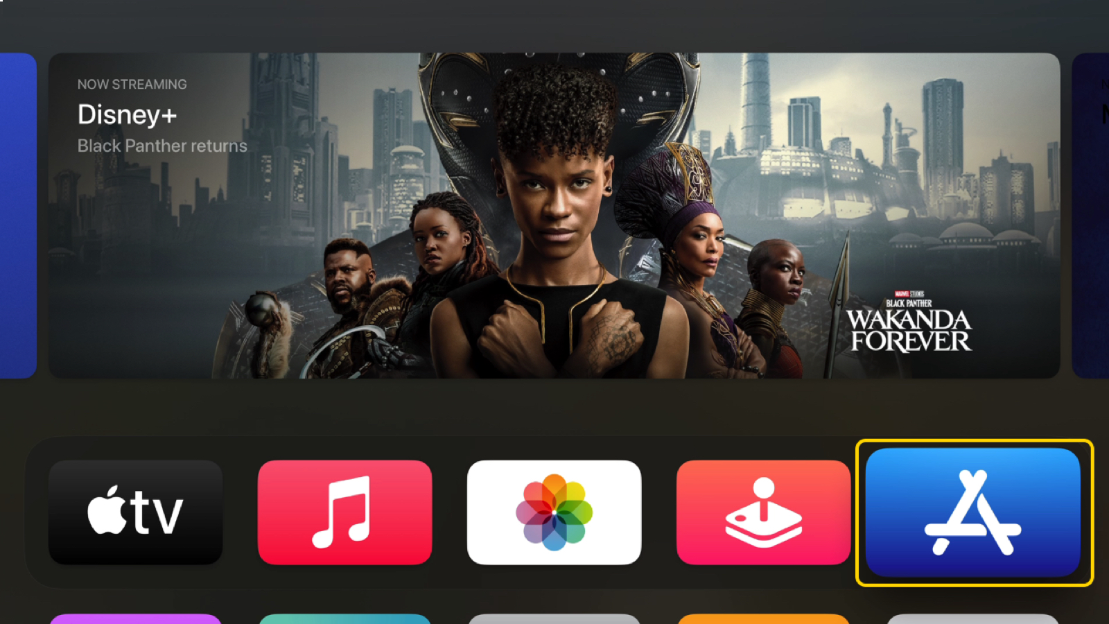 Het menu van een Apple TV op een TV met iconen an apps en een filmposter.