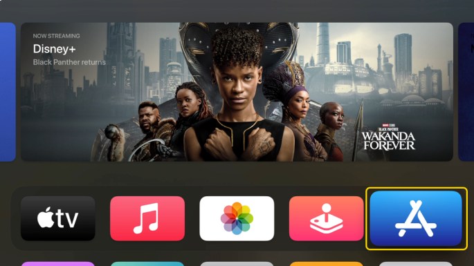 Het menu van een Apple TV op een TV met iconen an apps en een filmposter.